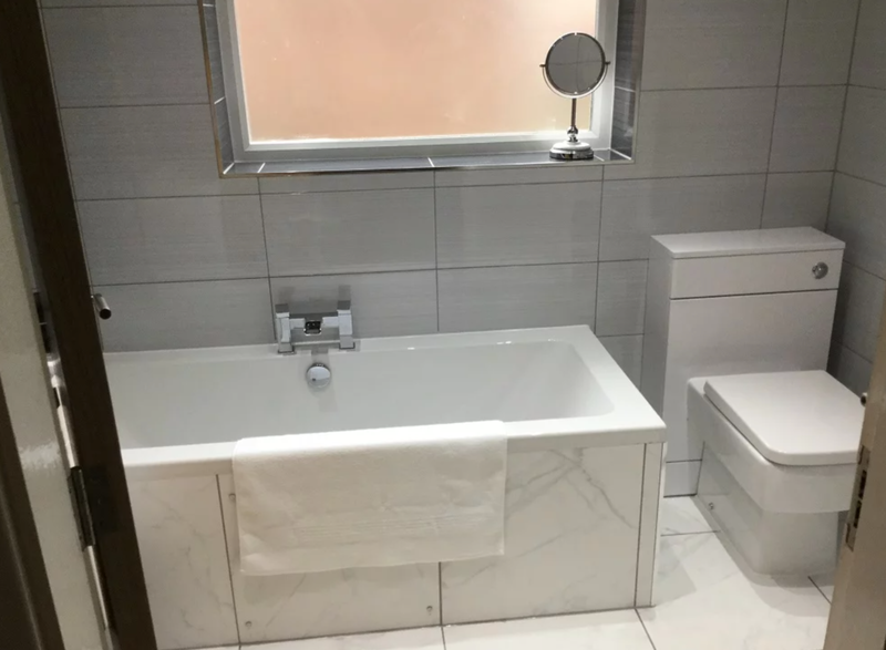 travertine-tiled-shower-beside-built-in-bathtub
